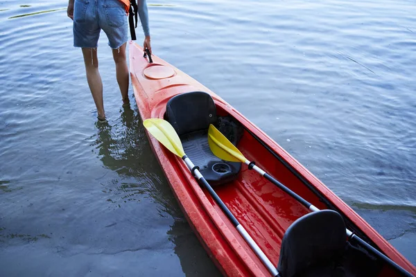 Close up shot of girl pulling canoe on water — Stock Photo, Image