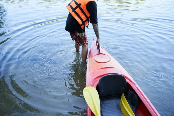 안전 한 외투를 입고 카누를 끄는 사람 — 스톡 사진