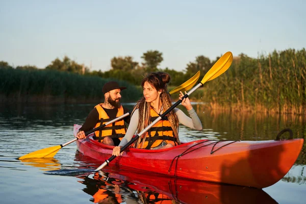 Couple de kayakistes nageant au coucher du soleil — Photo