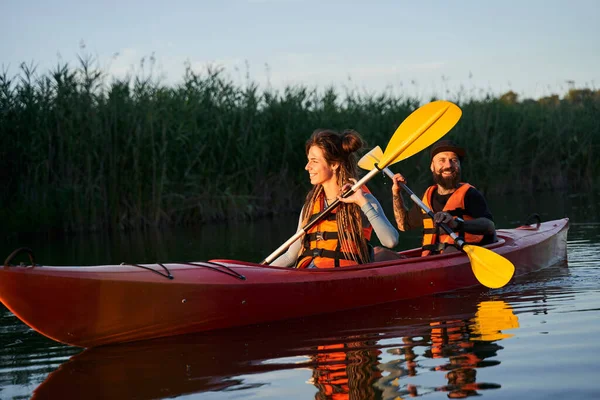 Glad familj paddling kajak vid solnedgången — Stockfoto