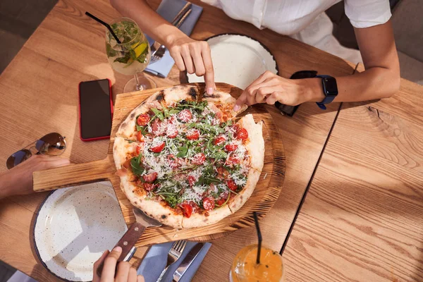 Flat-lay de mãos femininas tomando pizza — Fotografia de Stock