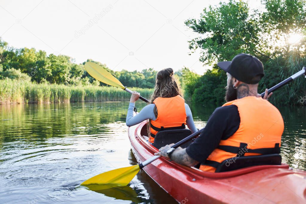 Loving couple kayaking on river