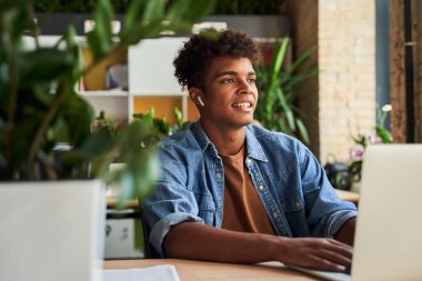 Erkek öğrenci kafede okuyor.