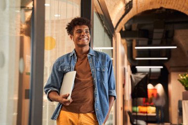 İşadamı laptopuyla yürüyor.