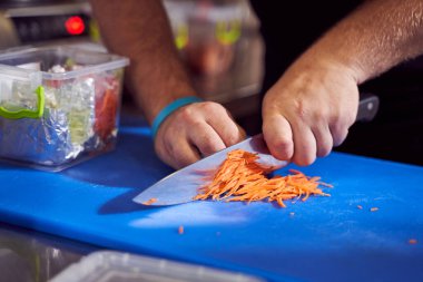 Aşçı mutfakta havuç kesiyor.