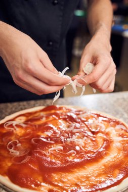 Adam hamur üzerine malzeme ekleyerek kapatır