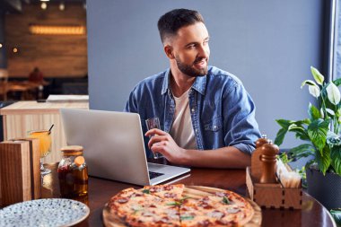 Pizza ve dizüstü bilgisayarla yakışıklı programcı.