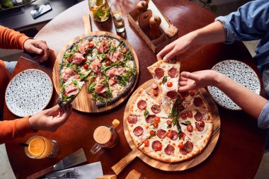 Yukarıdan pizza yiyen insanların görüntüsü