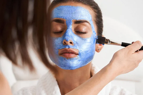 Güzellik uzmanı müşterilerin yüzüne maske takar — Stok fotoğraf