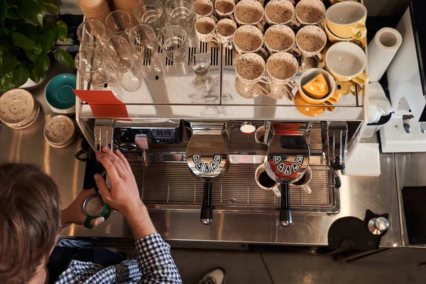 Barman schenkt koffie in bij de beker — Stockfoto