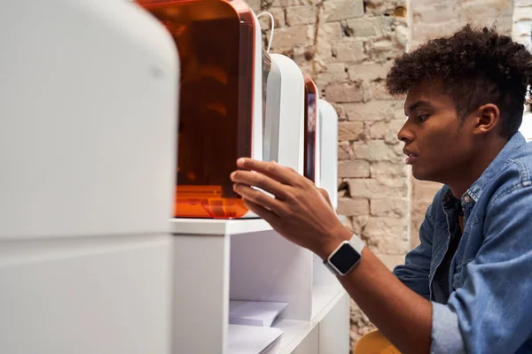 Man turning on the printer machine