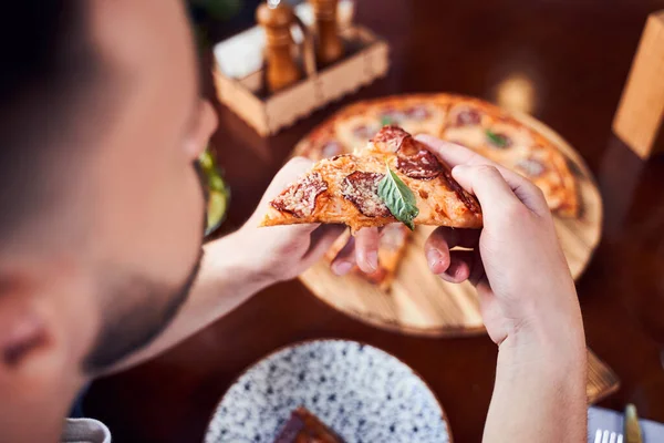 Vista de cima de homem com barba comendo pizza saborosa — Fotografia de Stock