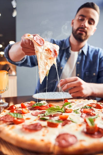 Homem com barba comendo pizza saborosa — Fotografia de Stock