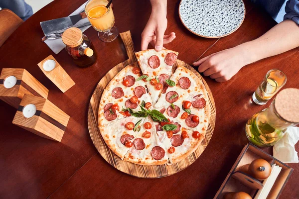 Meisje neemt plak pepperoni pizza — Stockfoto