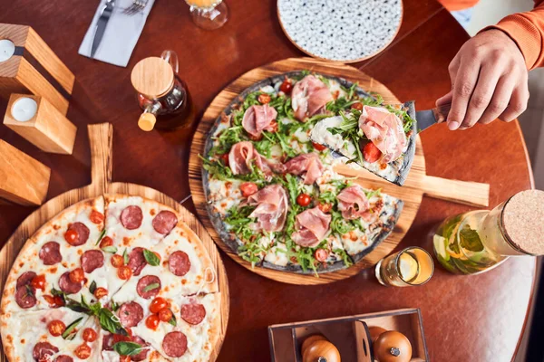 Vista dall'alto della ragazza che prende fetta di pizza al salame piccante — Foto Stock