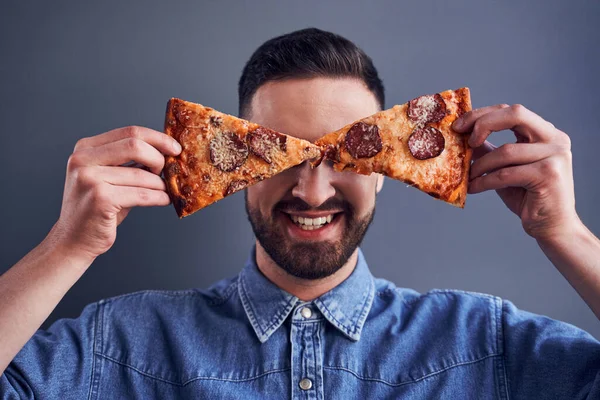 Man met baard die ogen verbergt met pizza plakjes — Stockfoto