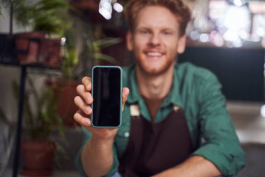 Çiçekçi cep telefonu ekranını gösteriyor