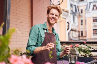 Barista dışarıdaki bitkilerle ilgileniyor.
