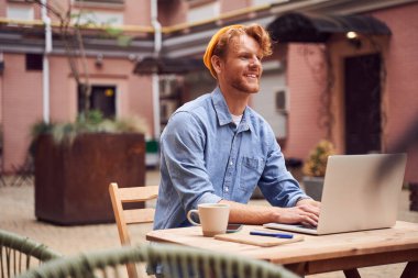 Bilgisayarda çalışan yakışıklı adamın düşük açılı görüntüsü.