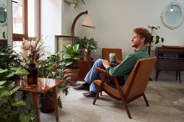 Florista sentada en silla bebiendo café — Foto de Stock