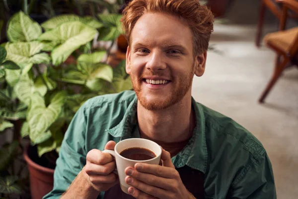 Röd huvud florist njuter av varmt kaffe — Stockfoto