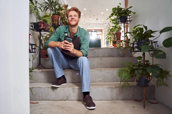 Trabajador guapo sentado en las escaleras — Foto de Stock