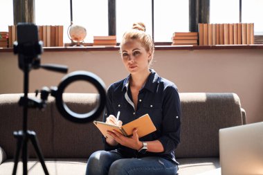 İnternette danışmanlık yaparken not alan sakin kadın