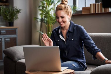 Ağ kamerasının önünde oturan pozitif kadın birini selamlıyor.