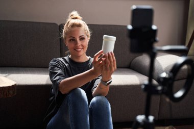 Kendine güvenen bayan internette kozmetik ürünlerinin reklamını yapıyor.