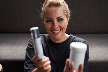 Güzel genç bayan kozmetik ürünleriyle mutlu görünüyor.