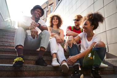 Neşeli arkadaşlar güneşli bir günü şehirde geçiriyorlar.