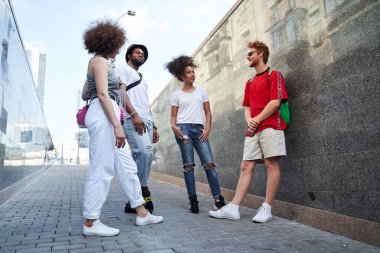 Dört gülümseyen insan yaya geçidinde iletişim kuruyor.