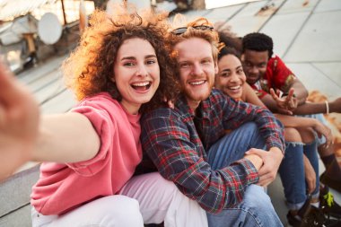 Mutlu arkadaşlar çatıda iyi vakit geçirir.