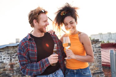Neşeli genç aşıklar dışarıda içkilerle eğleniyorlar.