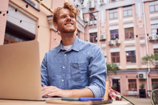 Low-Winkel-Aufnahme eines gutaussehenden Mannes, der am Laptop arbeitet — Stockfoto