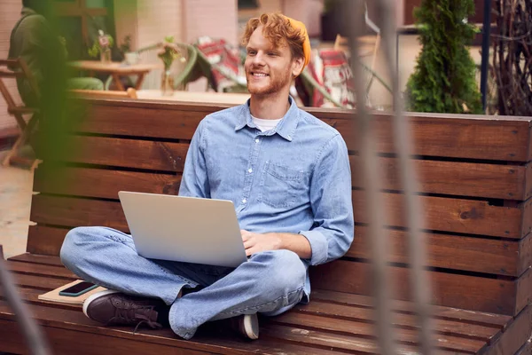 Homem trabalhando no laptop no banco — Fotografia de Stock