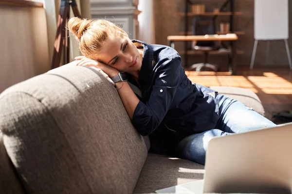 Mujer joven calma relajarse en casa con el ordenador portátil cerca — Foto de Stock