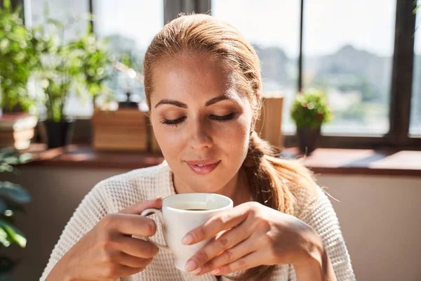 Señora pacífica disfrutando de su café de la mañana sola — Foto de Stock