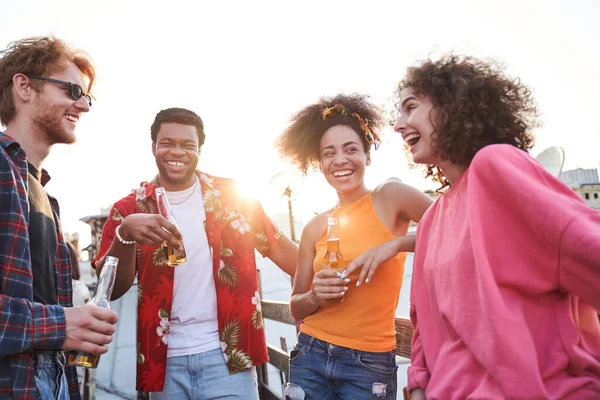 Gelukkige vrienden vieren met bier bij zonsondergang — Stockfoto