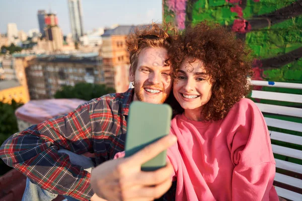 Šťastný mladý pár přičemž selfie při randění na střeše — Stock fotografie