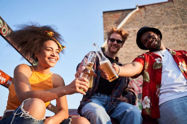 Troje wesołych przyjaciół świętuje z piwem na dachu — Zdjęcie stockowe
