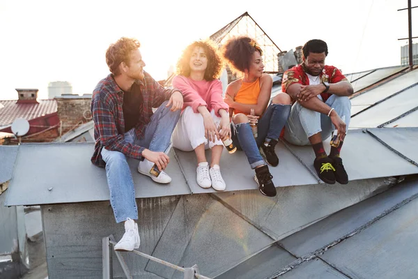 Счастливые друзья встречают закат на городской крыше — стоковое фото