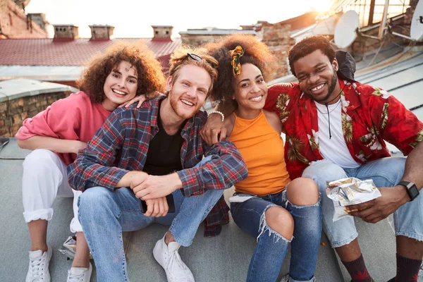 Usmívající se přátelé mají dobrý čas spolu na střeše města — Stock fotografie