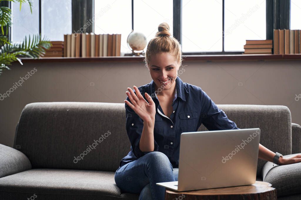 Friendly woman waving her hand in online meeting