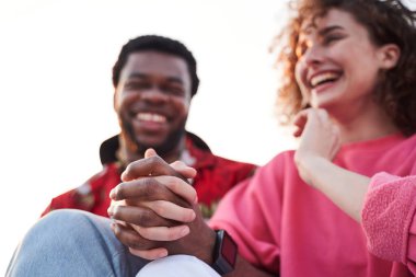 Dışarıda el ele tutuşan mutlu genç çift.