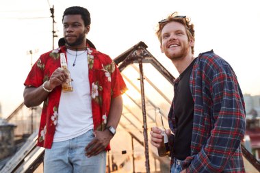 Açık havada bira içen mutlu genç adamlar