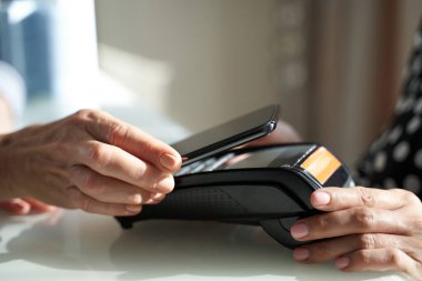 Cep telefonuyla ödeme yapan bayan müşteri