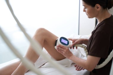 Kadın güzellik kliniğinde anti-selülit tedavisi uyguluyor.