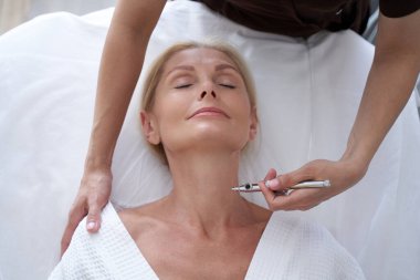 Cilt bakımı için modern teknolojileri kullanan deneyimli bir güzellik uzmanı.