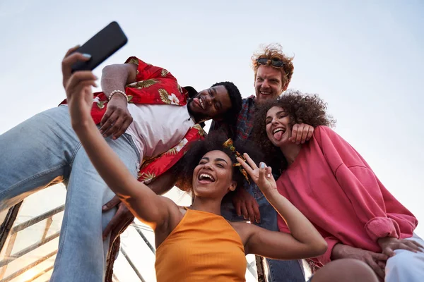 Veselí mladí lidé berou selfie na střechu — Stock fotografie